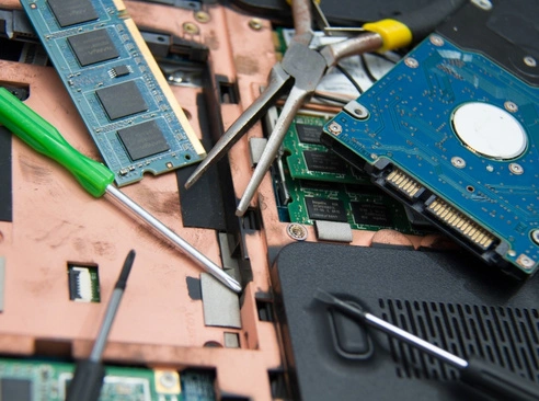 Why Choose Us for Computer Repair in Middle Park alt The image shows the internal components of a laptop laid out on a work surface Various parts like a hard drive, RAM modules, and circuit boards are visible