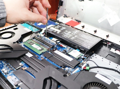 Why Choose Us for Computer Repair in Vermont alt The image shows a technician working on a laptop, carefully using a small tool to manipulate components inside the device